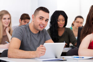 Male college student in a classroom studying sports psychology