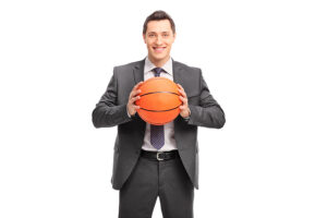 Male ports psychologist in a business suit holding a basketball